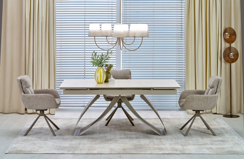 Jedilniška raztegljiva miza Hilario s svetlo ploščo v barvi kašmirja in svetlim podnožjem, v jedilnici z velikim oknom.