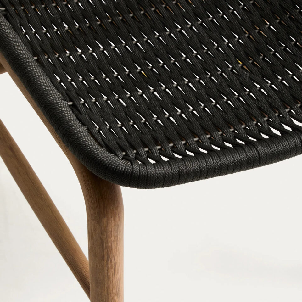 Detajl sedeža in noge črnega vrtnega stola Alipa, ki prikazuje teksturo ročno pletene vrvice in leseno konstrukcijo.